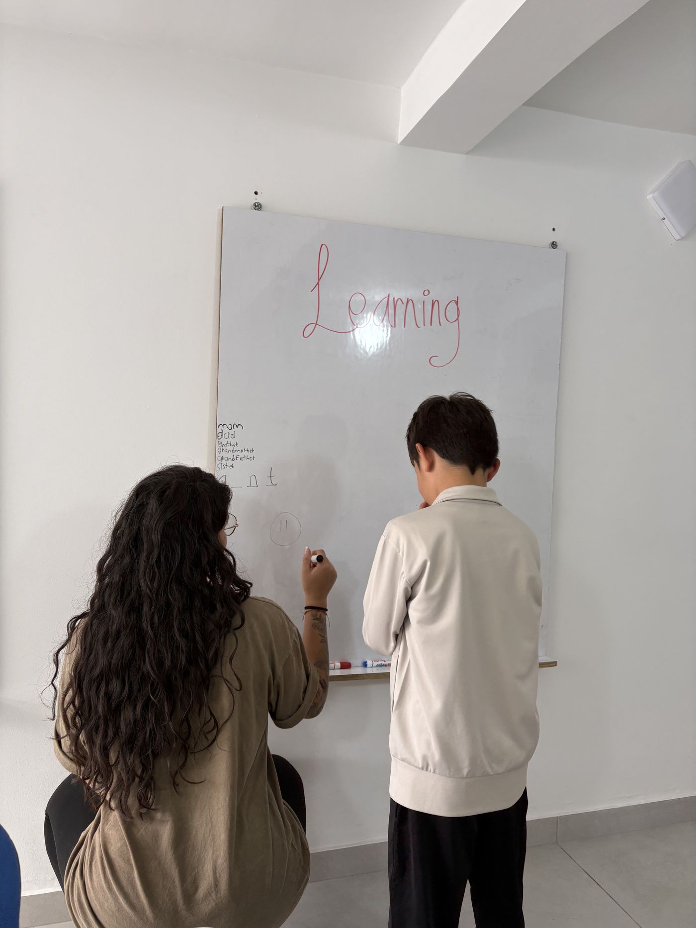 Clase de inglés frente al tablero con la palabra Learning